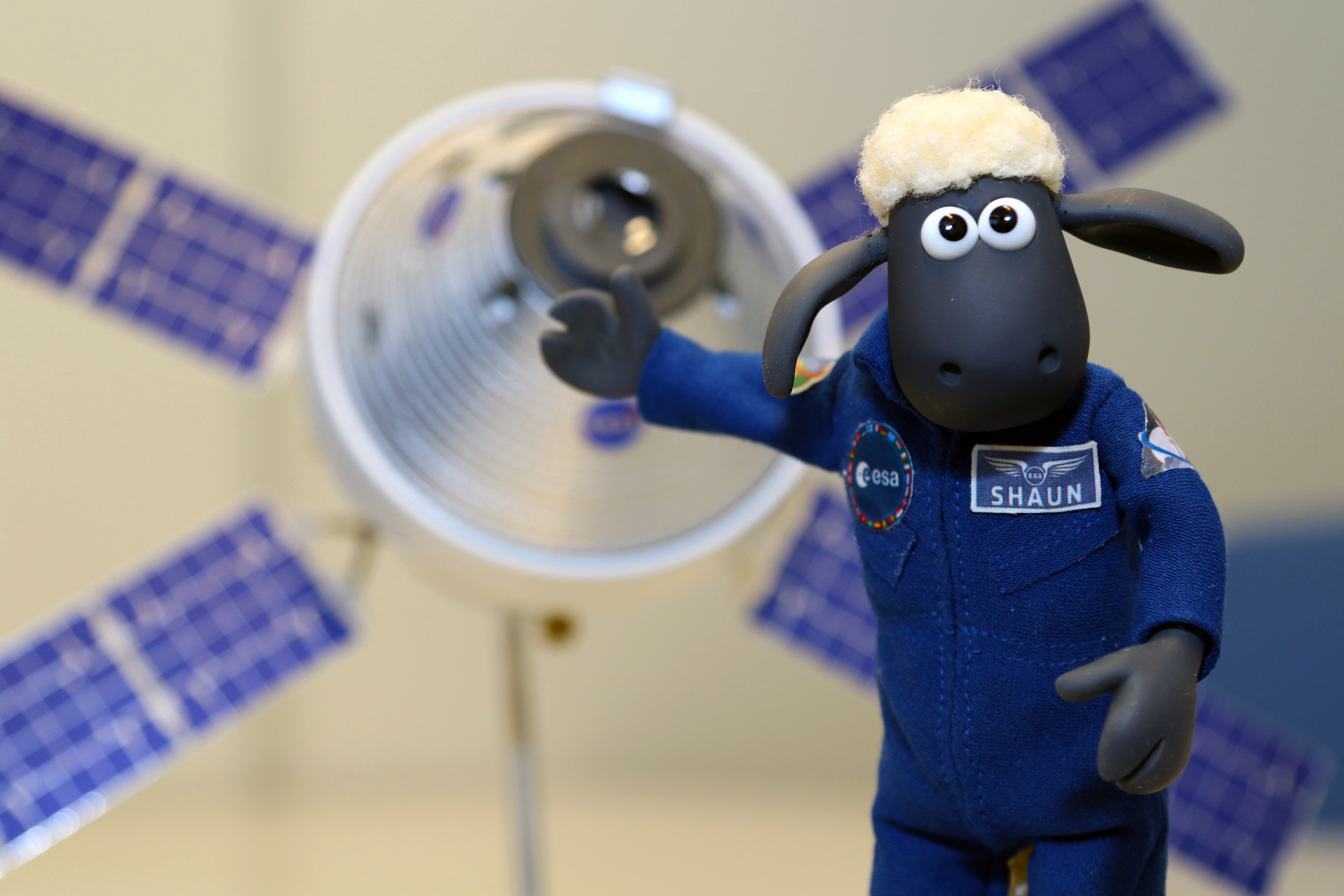 The character Shaun the Sheep (a small sheep) wearing an ESA astronaut uniform looking ready to start his mission