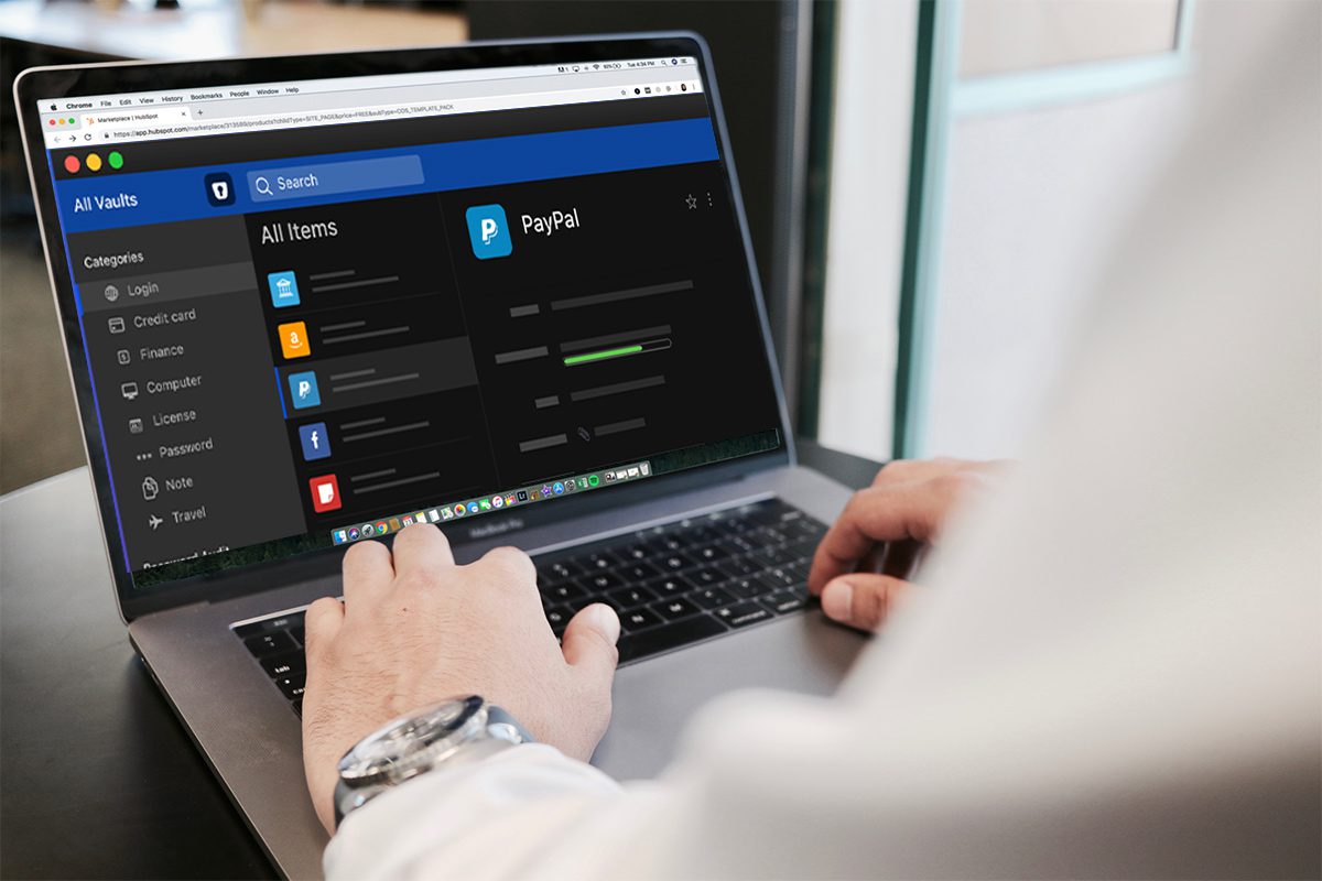 A man working on a laptop, with the screen showing a password management app.