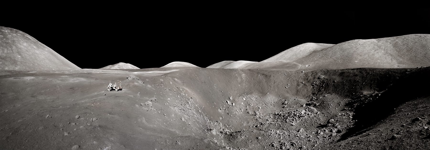 Harrison Schmitt peers into a crater on the surface of the Moon