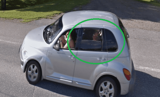 A silver car driving down the road on Google Street View. 