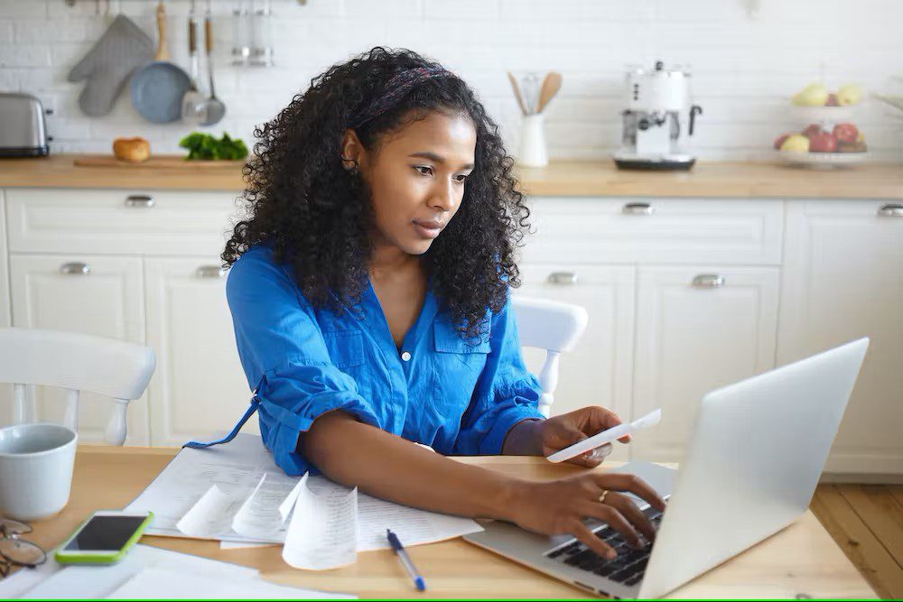 Woman on laptop at kitchen table