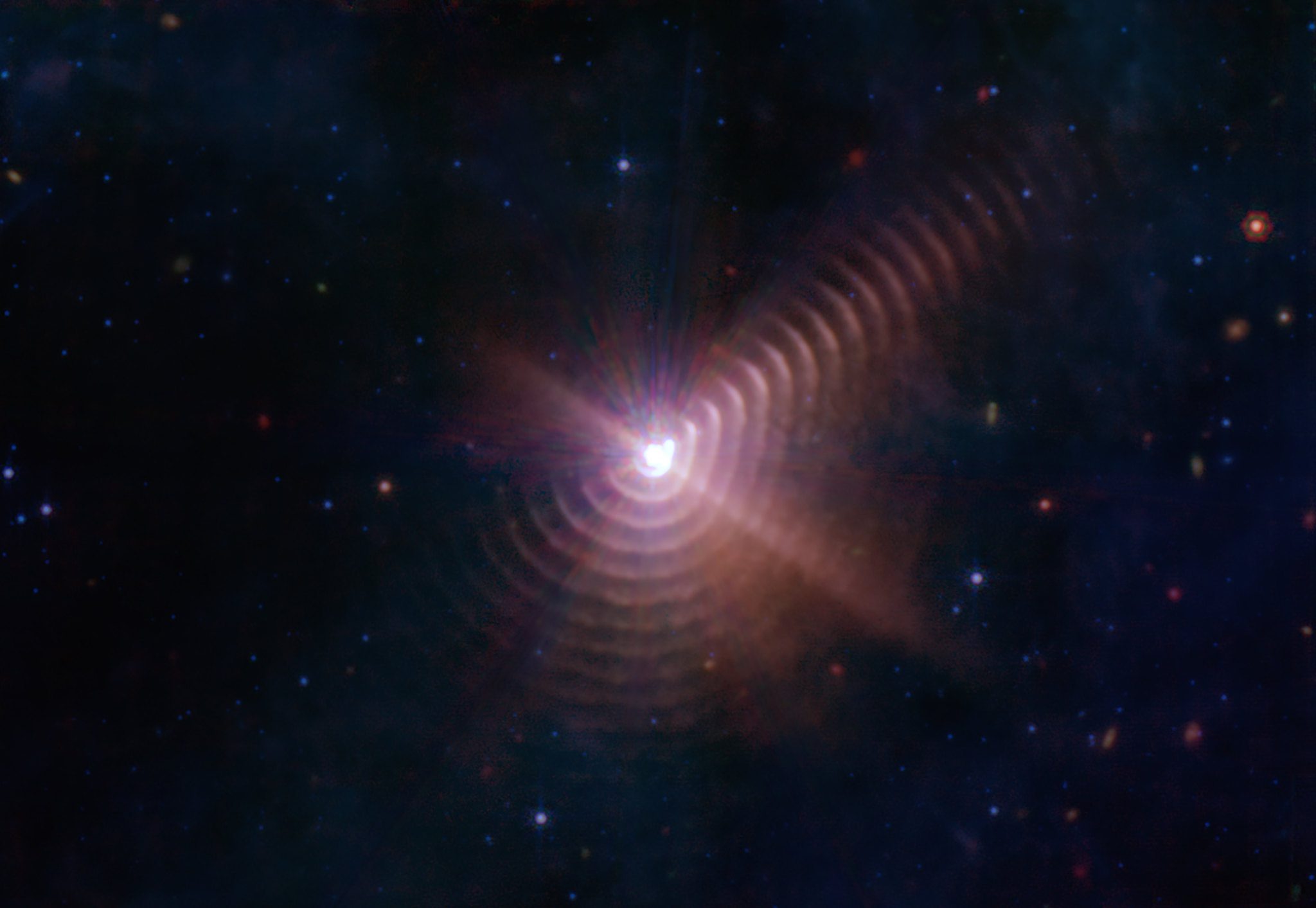 A helium-burning Wolf-Rayet star in a binary pair with another star releasing dust on an eight year cycle revealing the system's history. Image credit: NASA, ESA, CSA, STScI, JPL-Caltech