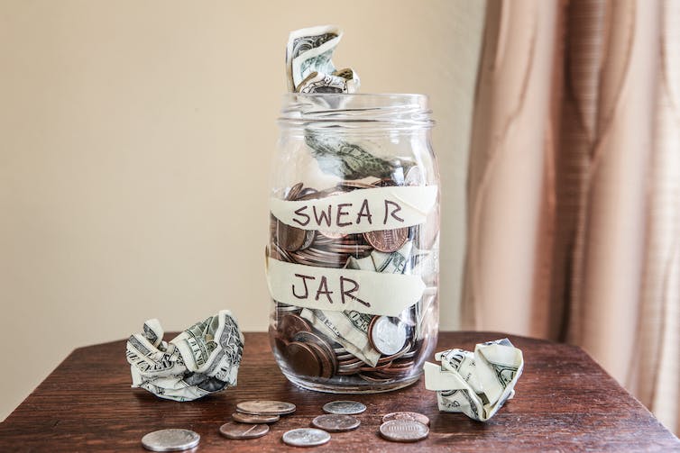 Swear jar to prevent swearing, filled with money