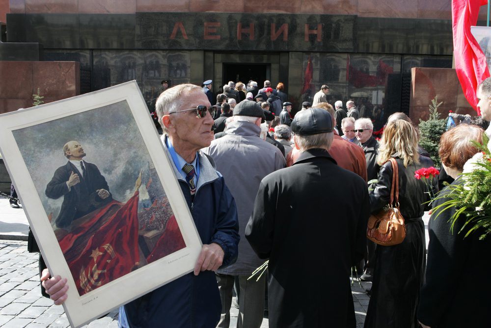 Russia man holds a picture of Vladimir Lenin marking the 138th anniversary of Lenin's birth in front of the Mausoleum at Red Square in 2008.