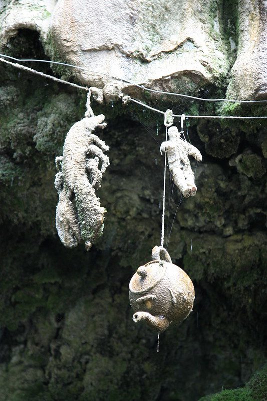 Photograph of a lobster, teapot, and doll at the petrifying well