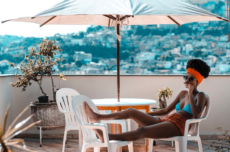 Woman sitting in bikini thinking.