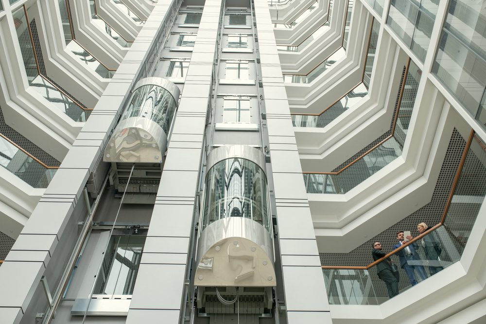 Two elevators ascending in a modern office building skyscraper. 