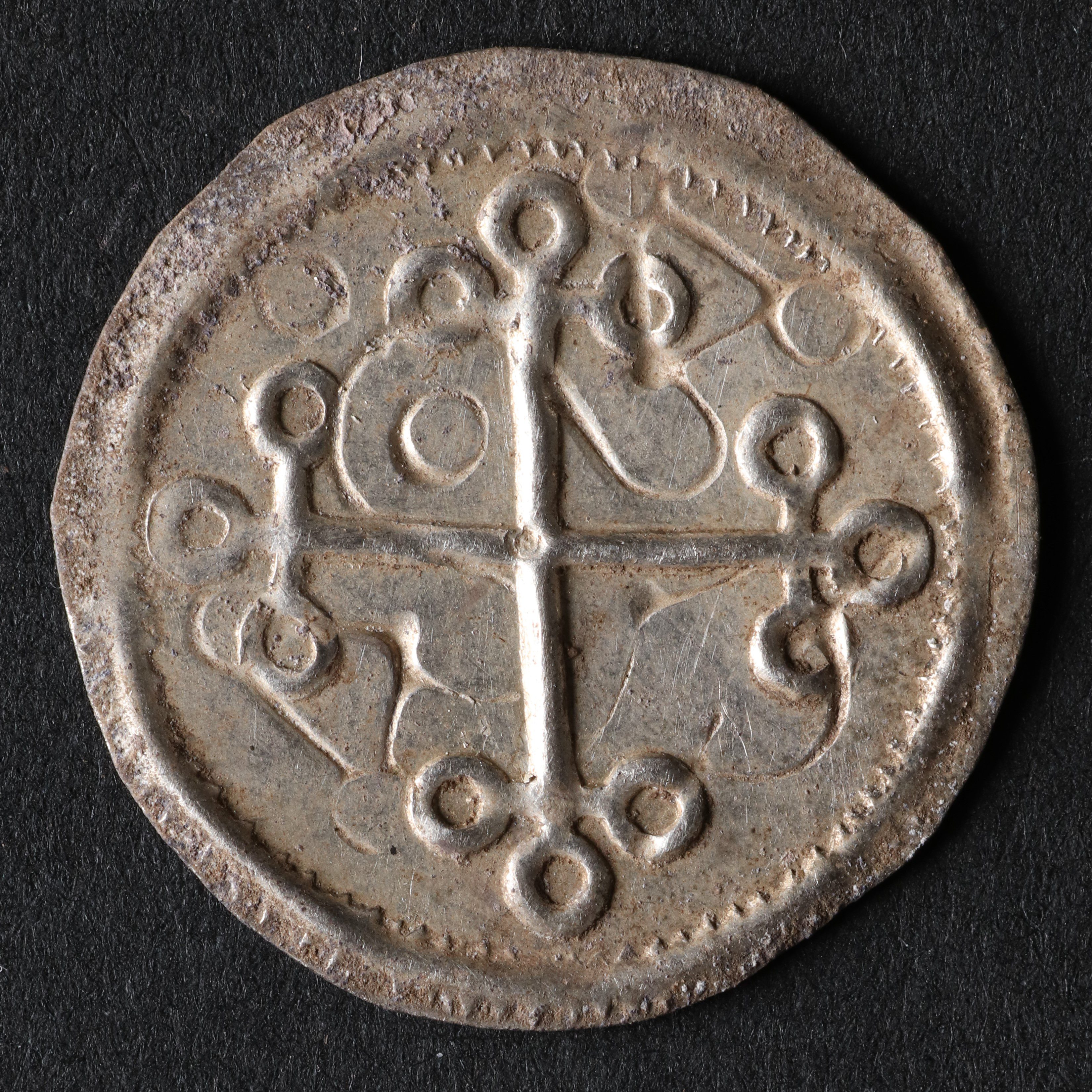 One of the coins recovered at the site, showing a cross