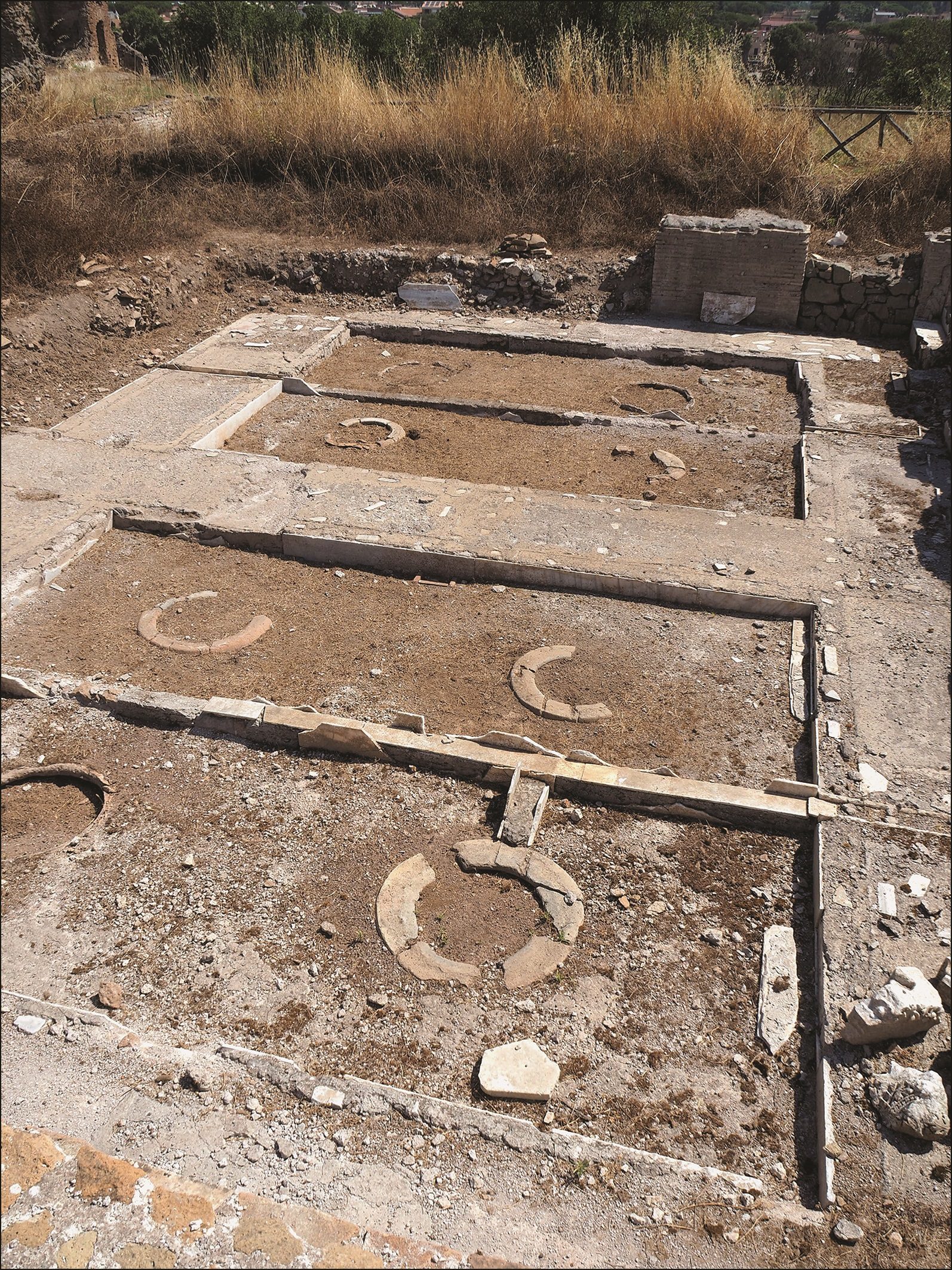 The cellar with marble-lined distribution channels and eight buried clay jars reinstated in their original positions. Image credit: Dodd et al., Antiquity 2023 