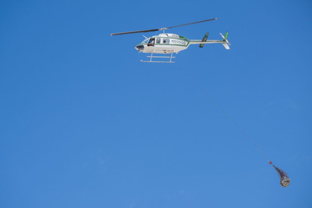 A helicopter practices transporting a mock sample capsule, packed for travel, at the Department of Defense’s Utah Test and Training Range. 