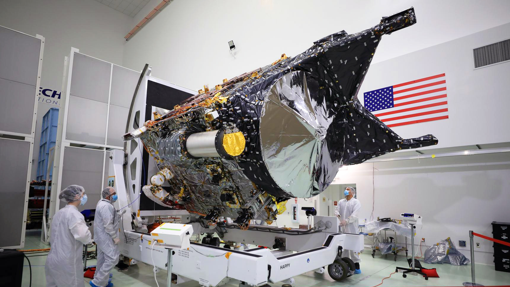 NASA’s Psyche spacecraft is shown in a white room at the Astrotech Space Operations facility. DSOC’s gold-capped flight laser transceiver can be seen, near center, attached to the spacecraft.