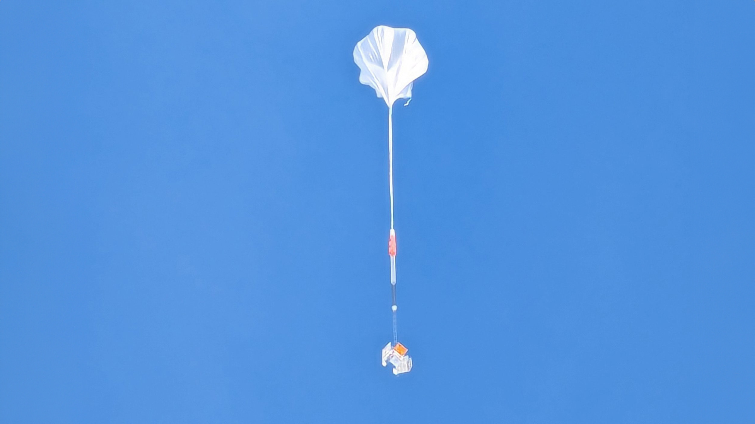 The GUSTO satellite being hoisted above Antarctica by the giant baloon.