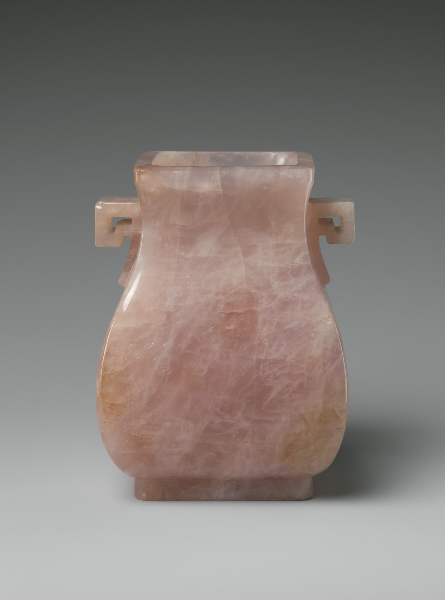 Photograph of rose quartz vase on grey background