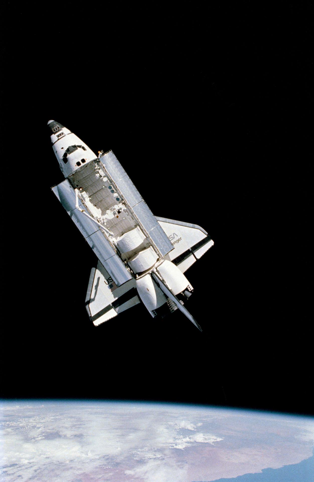 Image of Challenger space shuttle in space with Earth seen below.