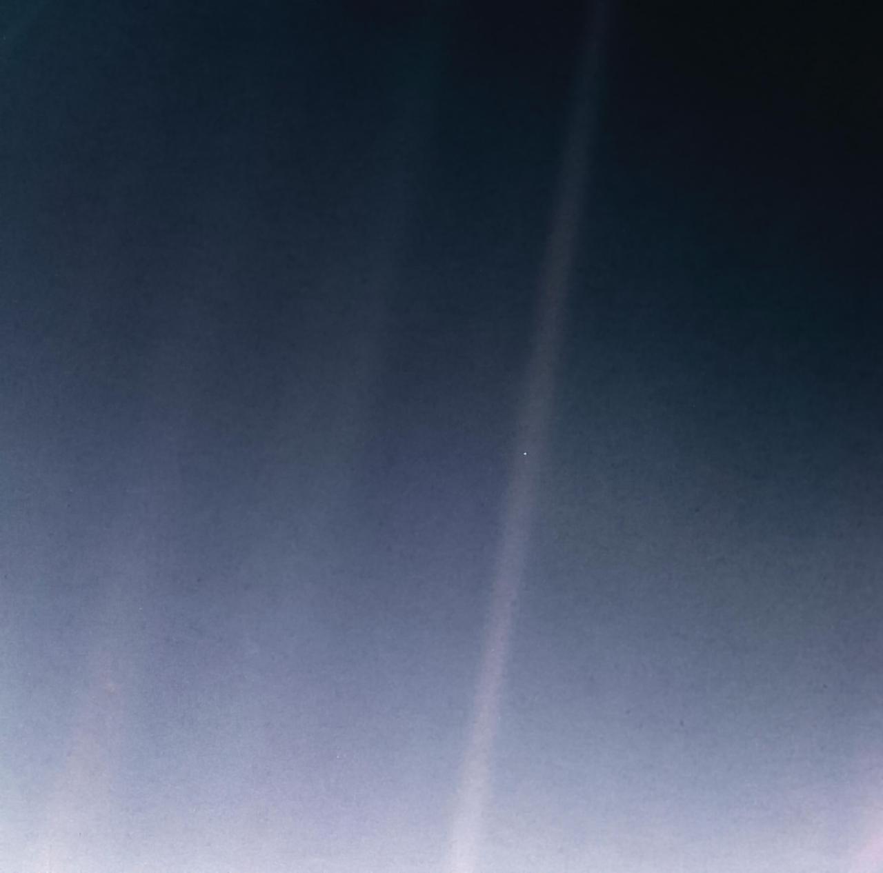 Remastered version of the Pale Blue Dot photograph taken by the Voyager mission in 1990; Planet Earth is visible as a tiny white speck towards the center of the otherwise blue/grey image