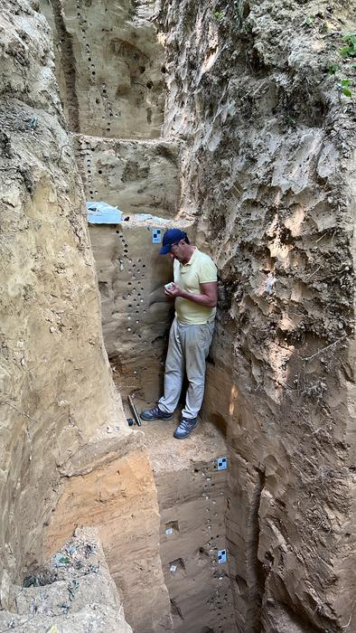 Loess section being sampled for integrated stratigraphy in Krakow-Zwierzniec, Poland, with researcher standing on level with evidence of early occupation by H. sapiens. 