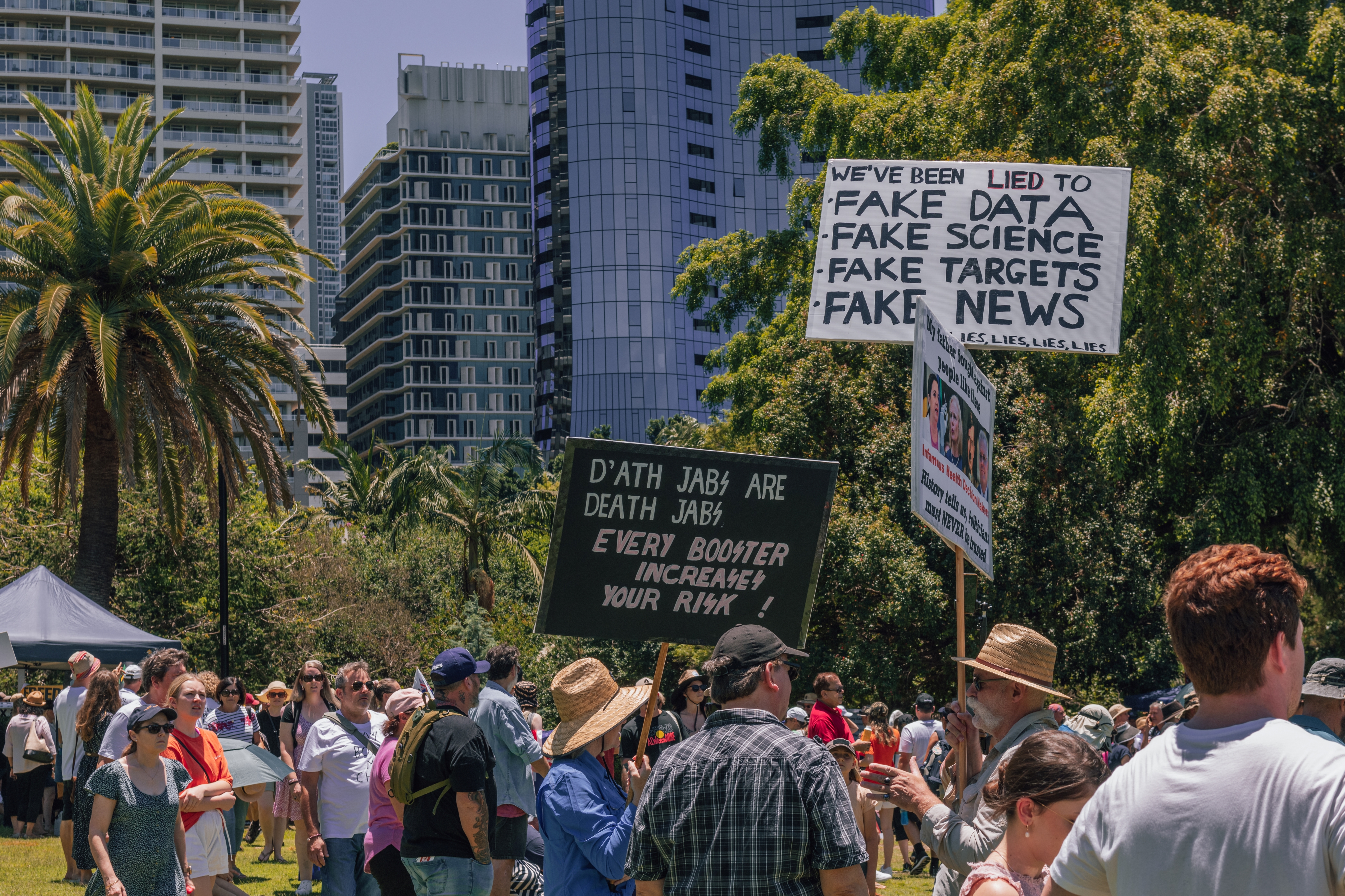 Brisbane, Australia - November 20, 2021: protestors with signs at an anti vax mandate rally.