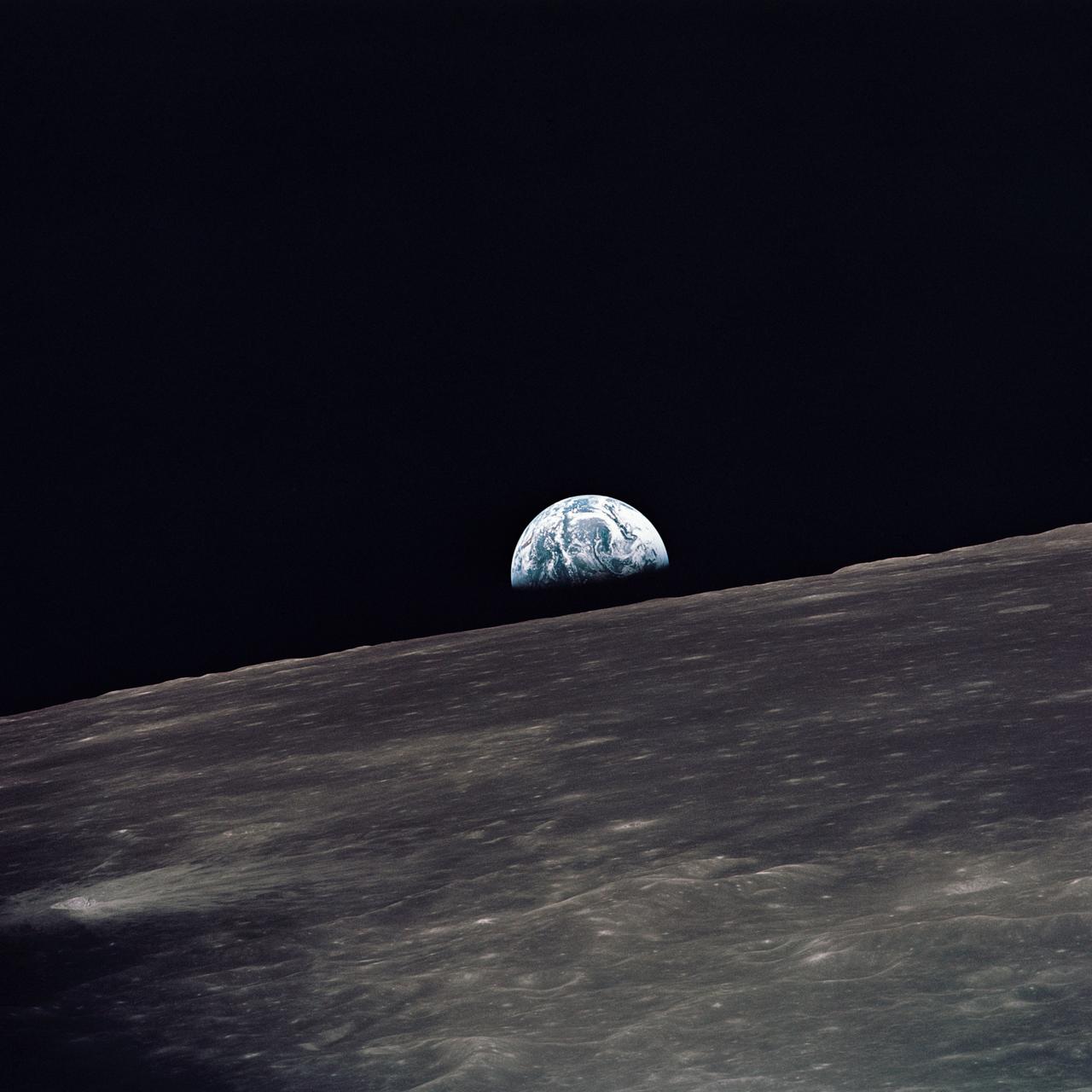 A view of Earth rising above the lunar horizon photographed from the Apollo 10 Lunar Module, looking west in the direction of travel. The Lunar Module at the time the picture was taken was located above the lunar farside highlands at approximately 105 degrees east longitude.