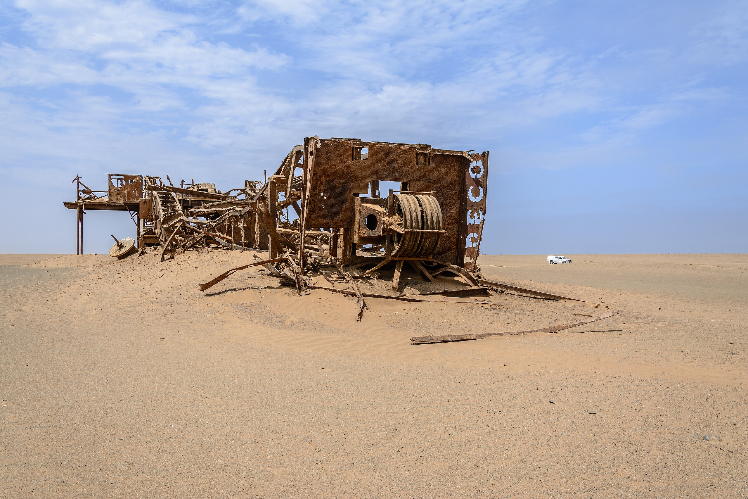 An old rusted and decayed oil rig(?) in the middle of the desert