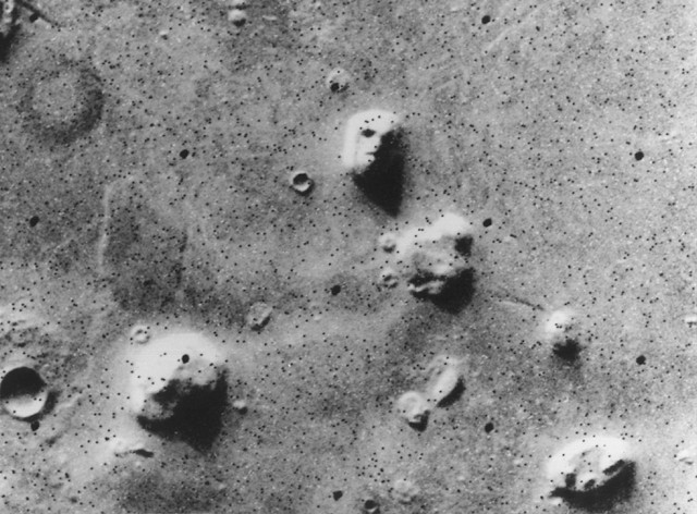 The area shows a few craters and several mounds. One of them is the face. Half in shadow, the lighted part shows feature that look like an eye socket, a nose, a motuh and a hairdo.