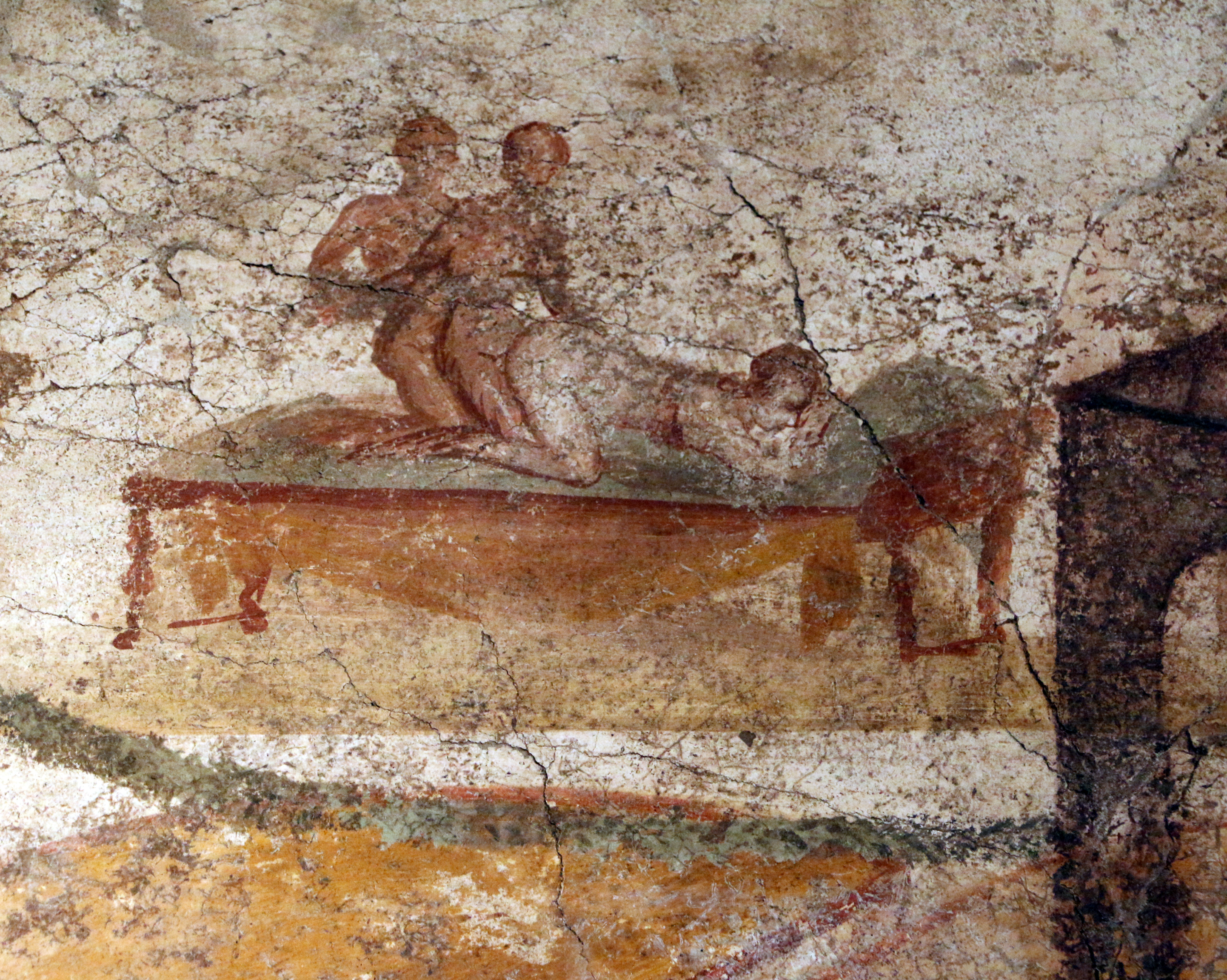 A fresco showing a woman kneeling forward on a bed as she is penetrated from behind by a man who is himself being penetrated by another man. A fresco showing a woman kneeling forward on a bed as she is penetrated from behind by a man who is himself being penetrated by another man.