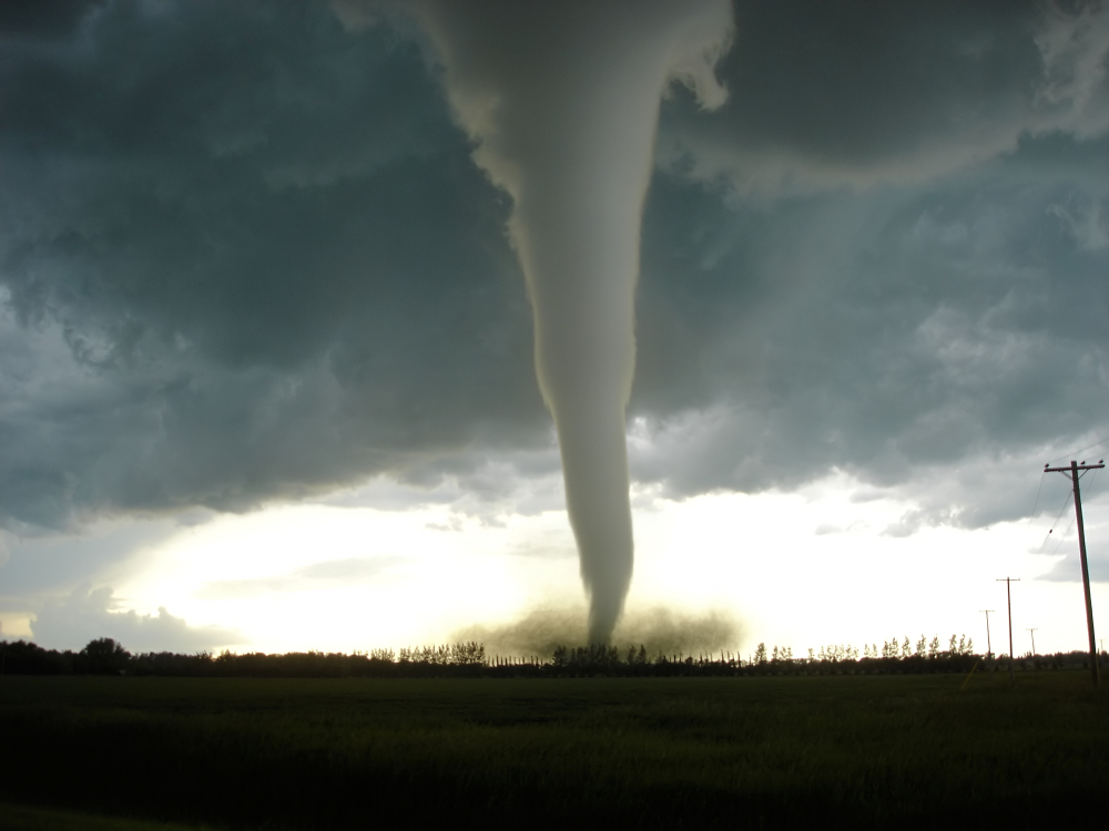 a tornado cloud on a farm, the sky is dark