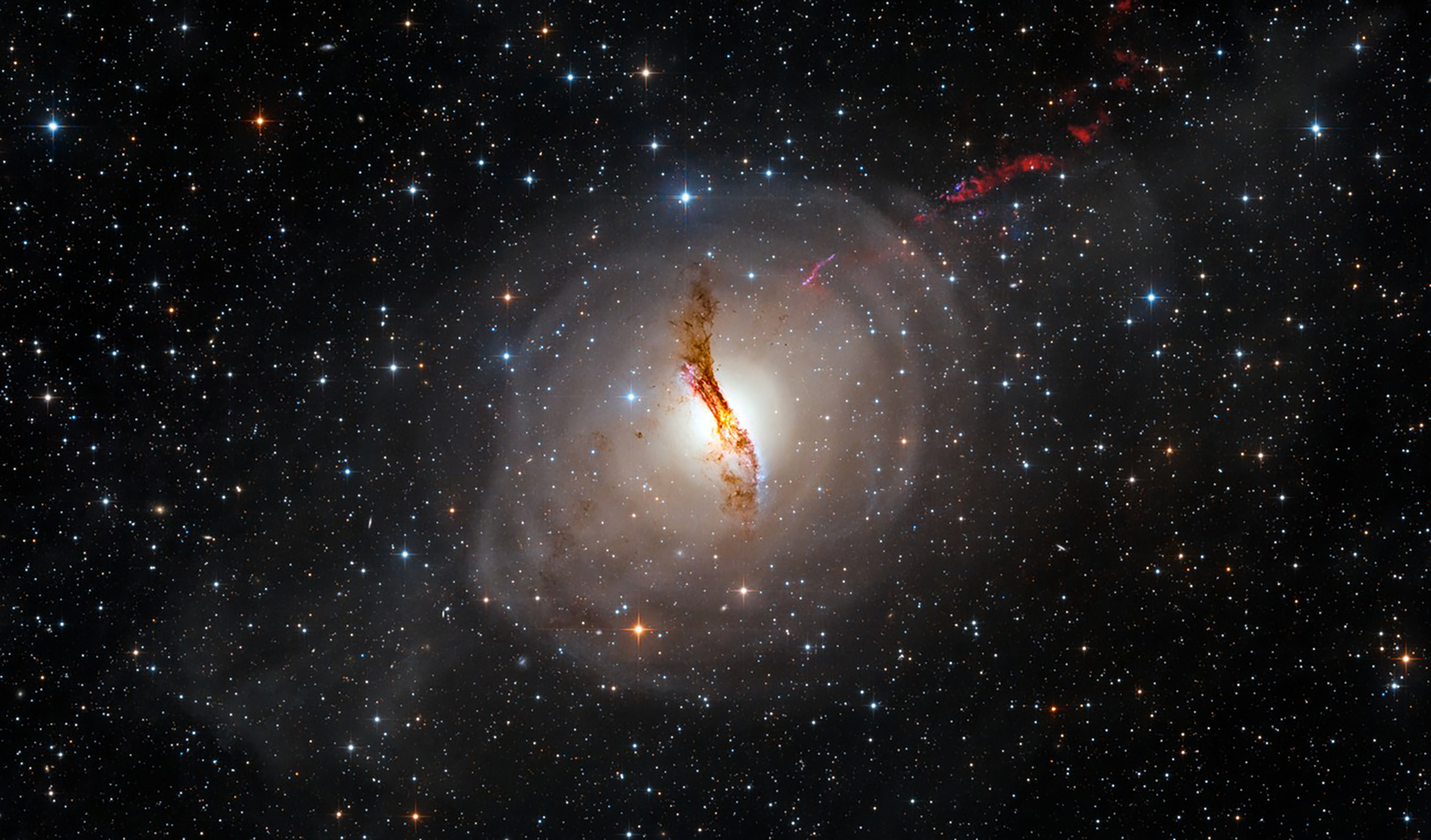 An elliptical galaxy with a massive dust lane in the middle as well as the dust shells from the interactions that formed it and the jet of the black hole at its center