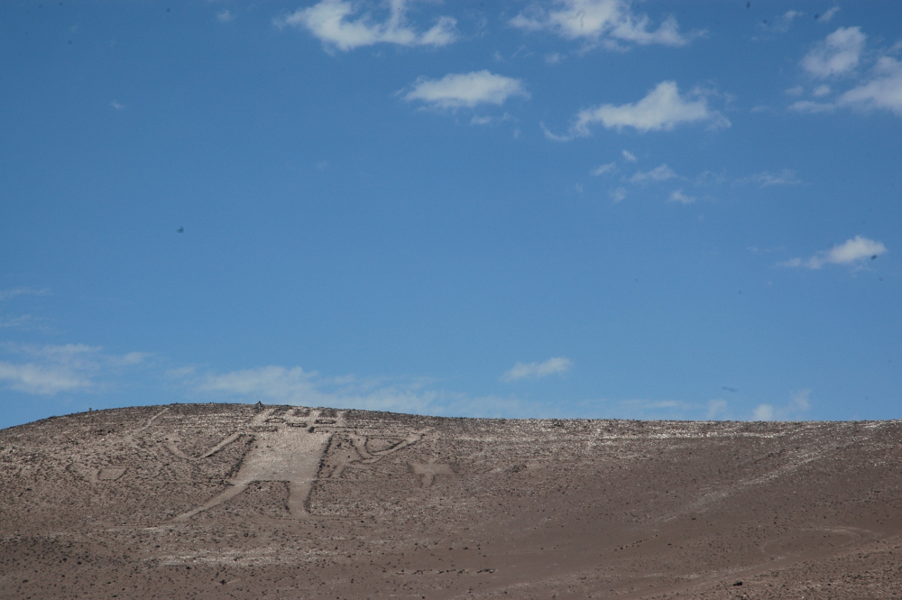 a hillside in chile with the atacama giant scratched into the surface