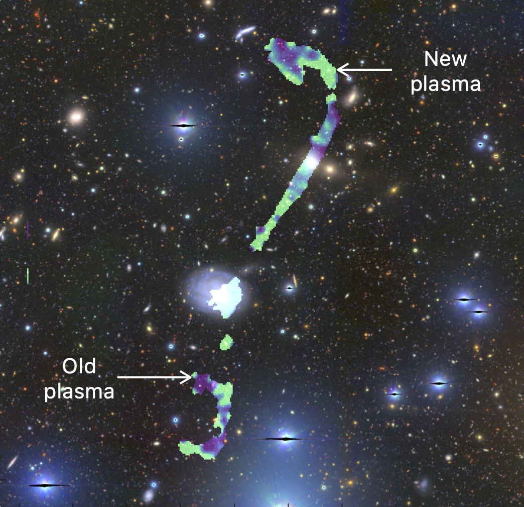 The galaxy at the center has two thin structures stretching out. The one at the bottom is short and shaped like a reverse c. The one at the top is long and shaped like a candy cane. the one of the top has alot more young plasma. 