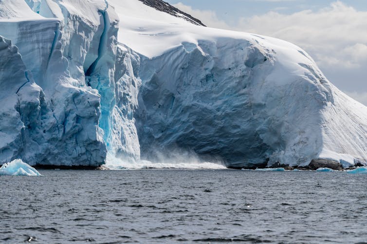 A giant chunk of ice calving off an ice sheet.