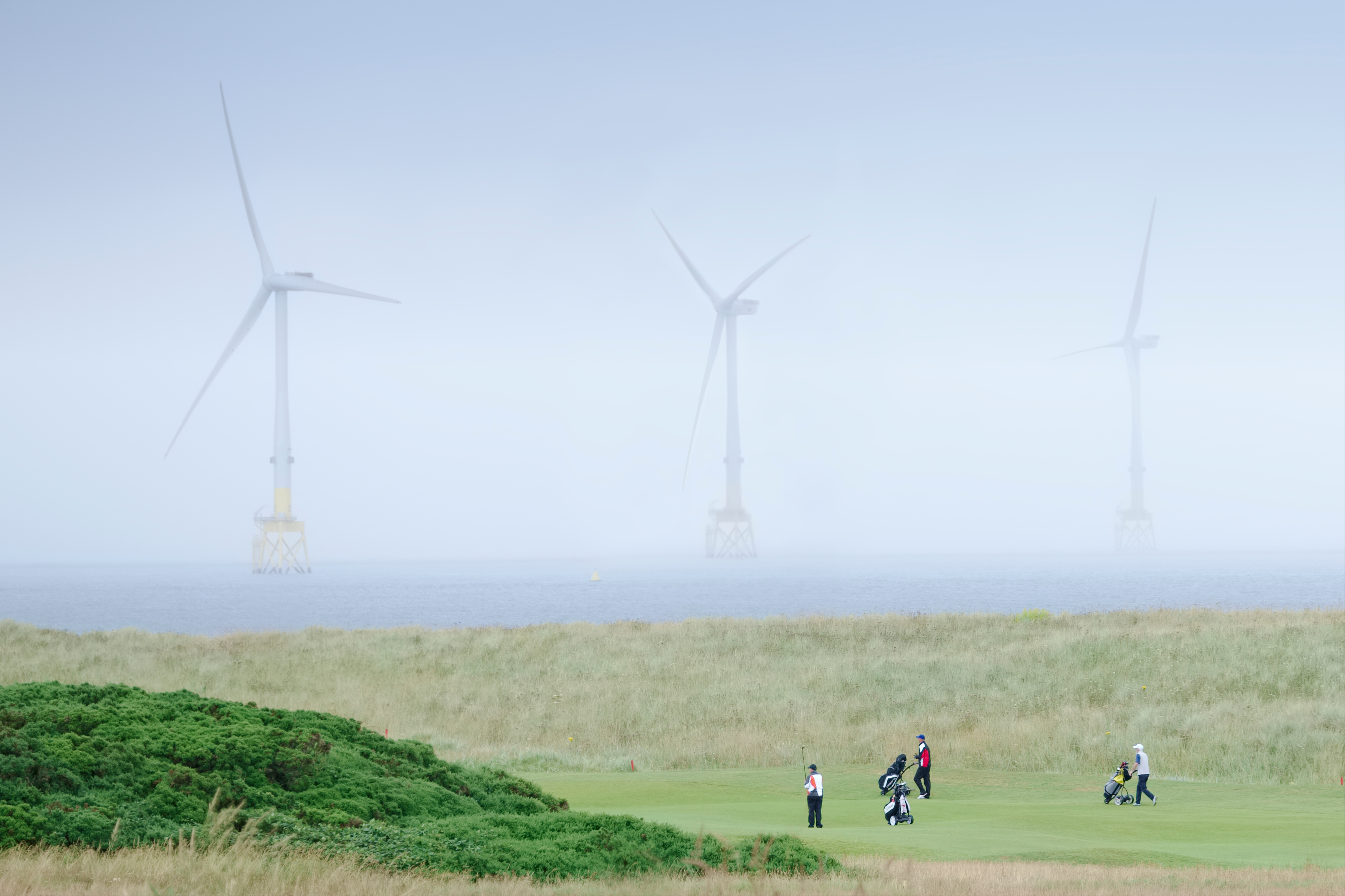 Wind turbines in the North Sea loom over the Trump International Golf Links Aberdeen in Scotland.