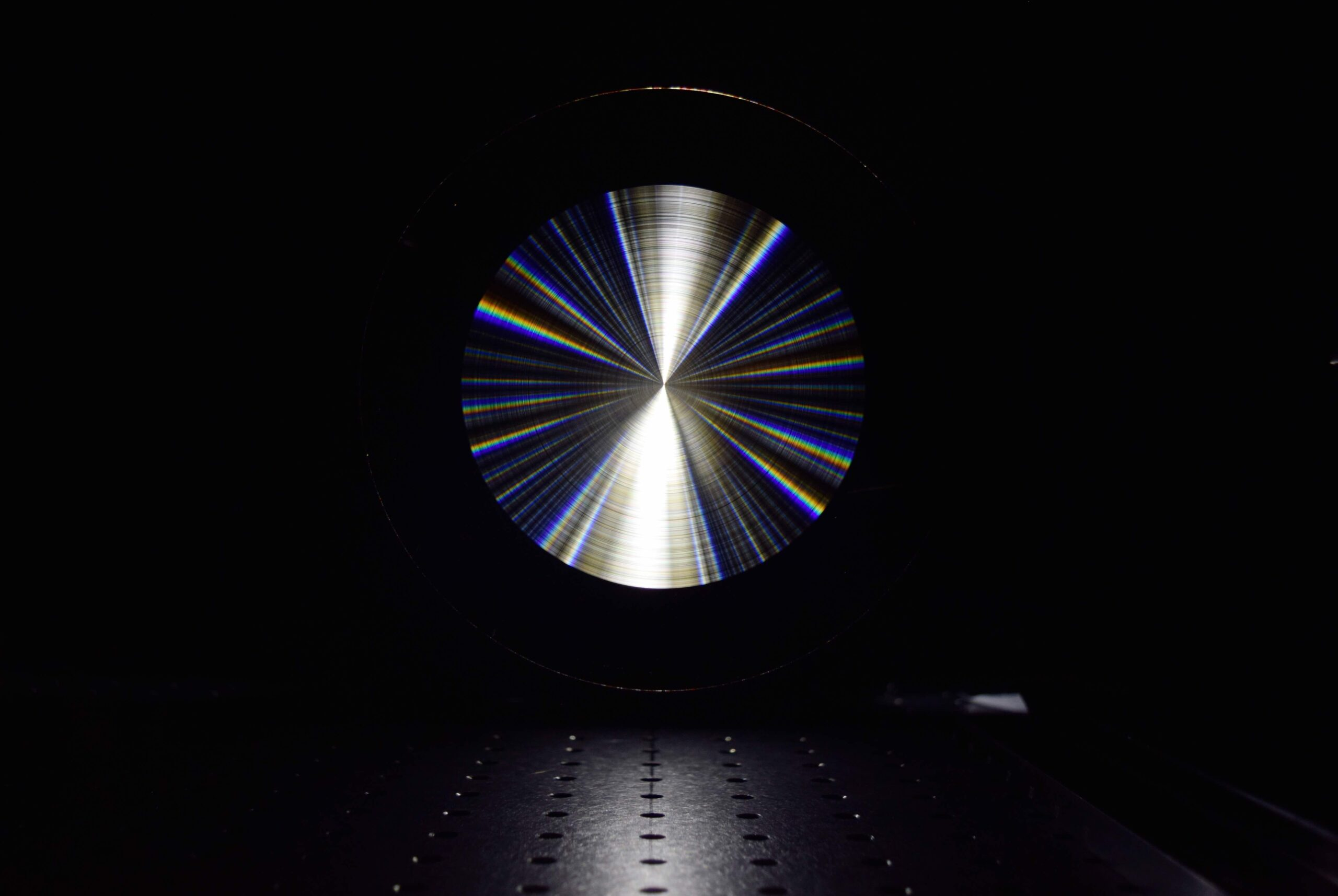 Light bouncing off the surface of the lens produces a rainbow of colors like a CD, but with much higher precision.