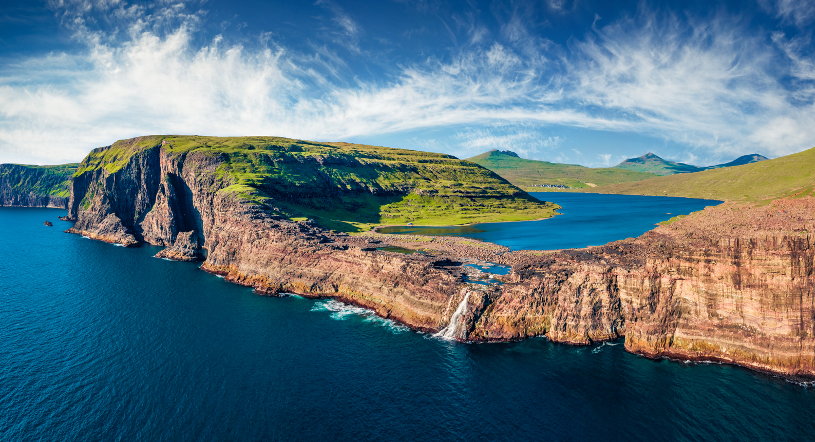 Panoramic view from flying drone of Bosdalafossur waterfall. Amazing summer scene of Sorvagsvatn lake, Vagar, Faroe Islands, Denmark, Europe. Beauty of nature concept background. 