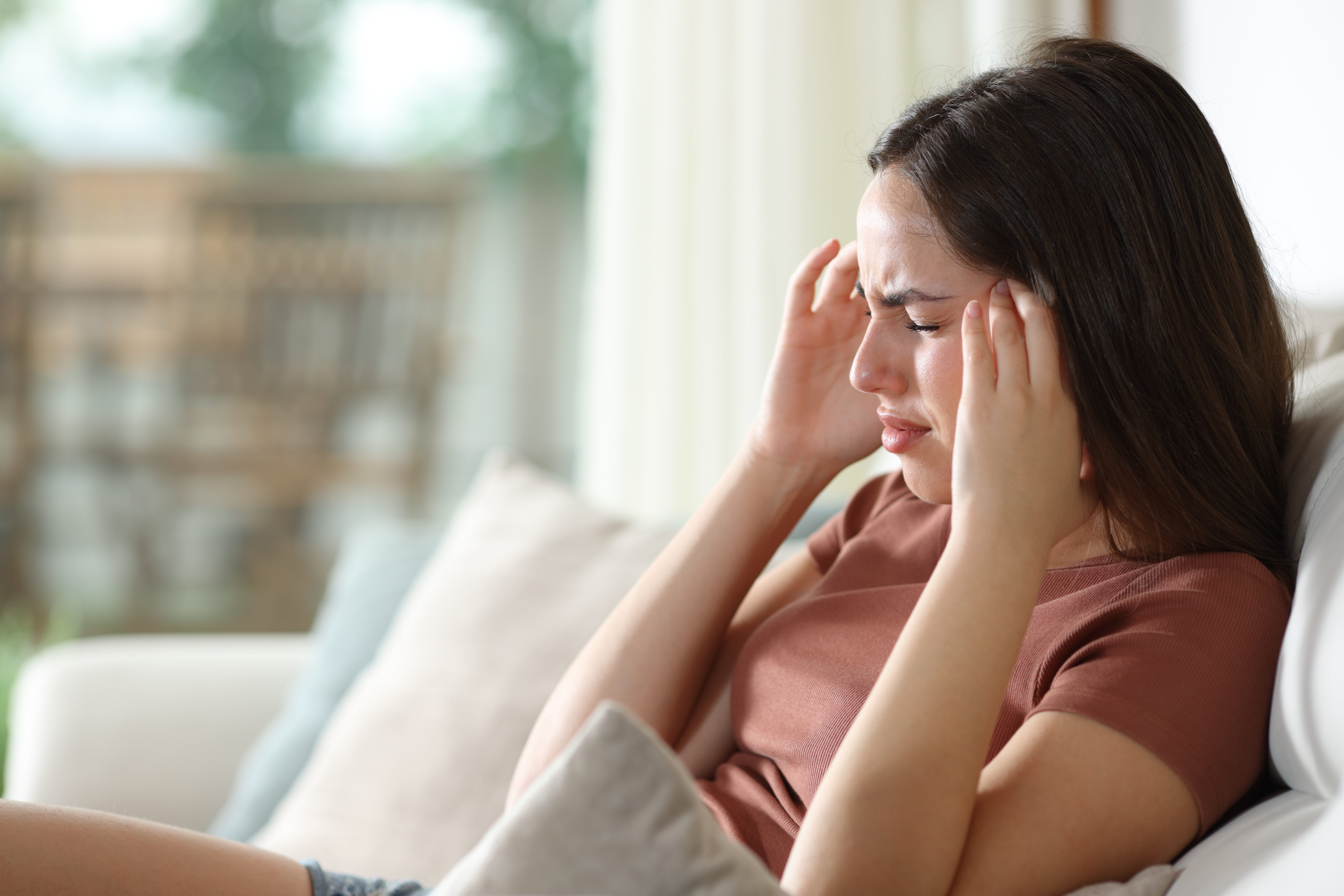 Woman touching her head in pain Woman touching her head in pain