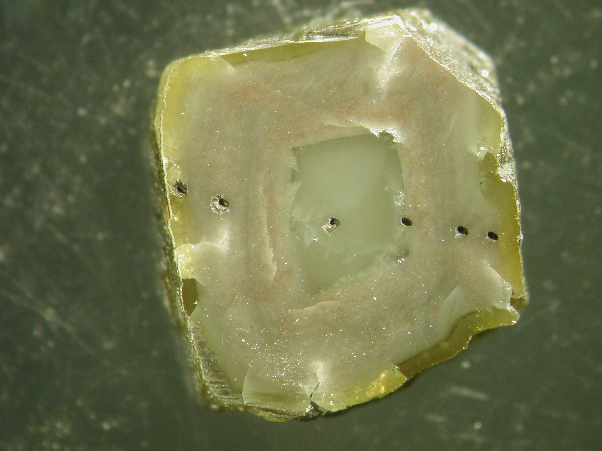 The dark dots on this diamond come from laser ablation pits used to take microscopic samples for chemical analysis. The dark dots on this diamond come from laser ablation pits used to take microscopic samples for chemical analysis.