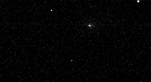 A black space background dotted with small white stars. Near the centre, a slightly fuzzy, bright white dot moves downward through a set of frames – this is comet 3I/ATLAS