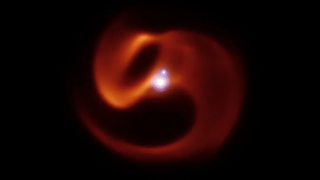 two bright points of light are in the middle and are surrounded by an s shaped orange shell