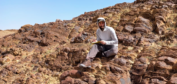 First author James Pierce sitting on some of the rocks whose regular stratigraphy allowed the team to make sense of the changes.  First author James Pierce sitting on some of the rocks whose regular stratigraphy allowed the team to make sense of the changes.
