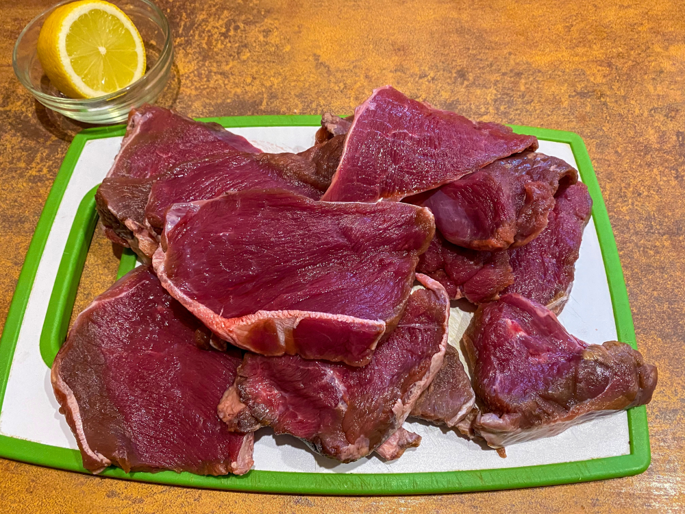 cuts of moose meat on a chopping board