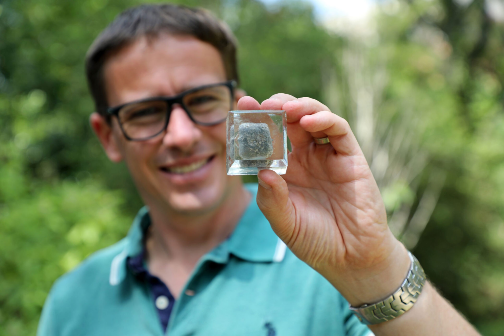 a scientist holding up square wombat poop